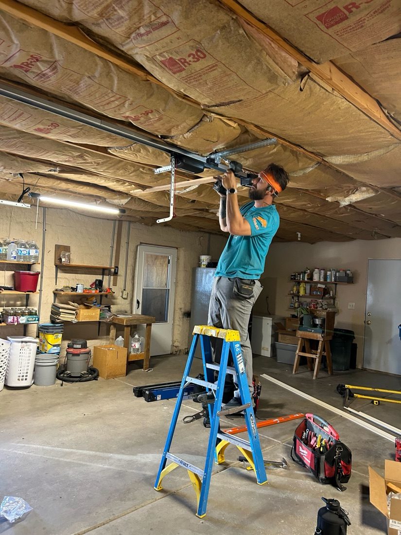 A Kooler Kraftsman working the hardware on a garage door section during an install