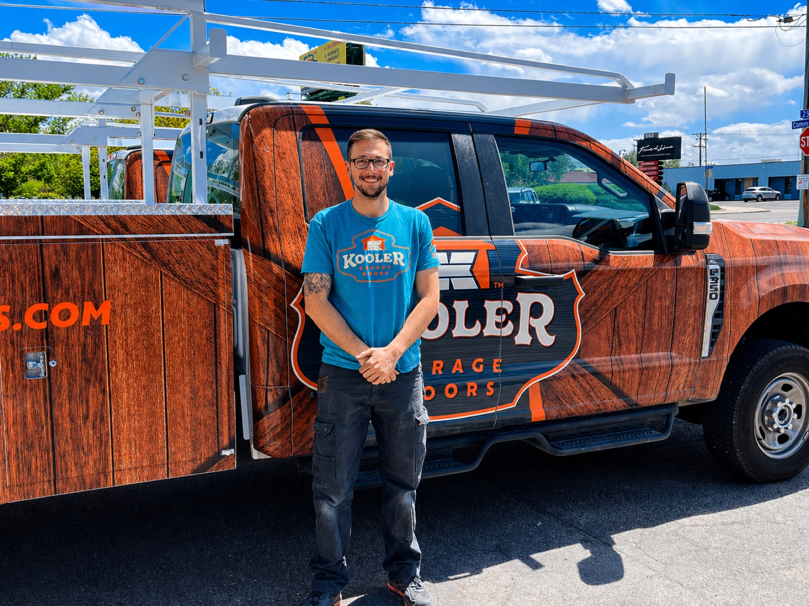 A Kooler Garage Doors Kraftsman standing in front of the branded service truck