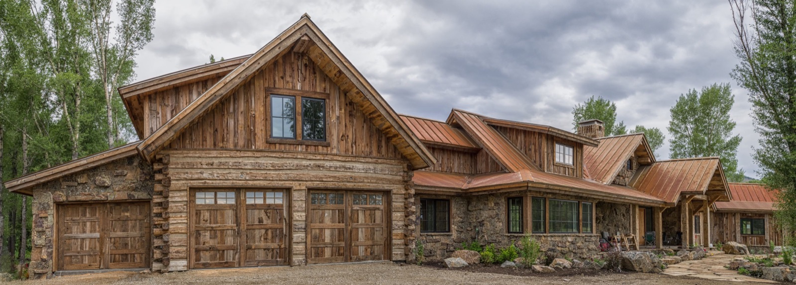 Hand-built log home with matching stained-wood carriage garage doors